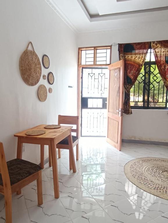 a dining room with a table and a door at Ubuntu Home in Mto wa Mbu