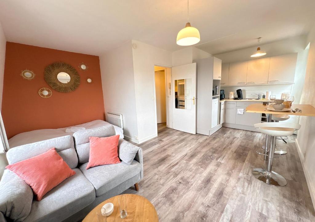 a living room with a couch and a kitchen at Studio central équipé in Compiègne