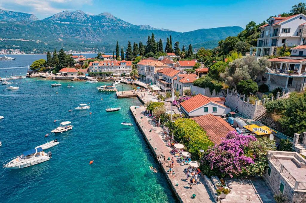 a town on a river with boats in the water at Stone Rose Glamping & Apartments in Tivat