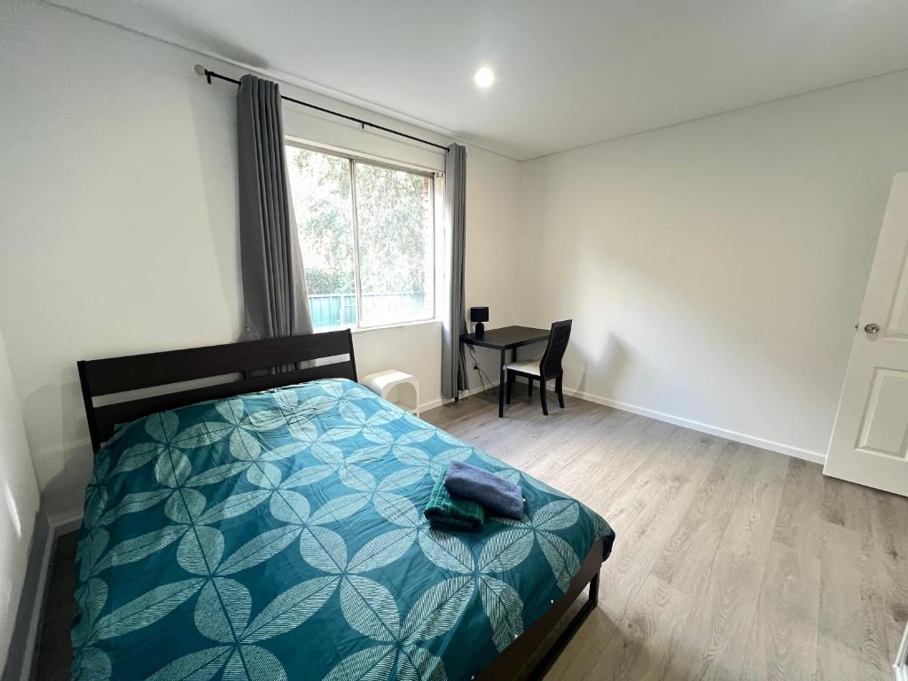 a bedroom with a bed and a desk and a window at Spacious Queen Room - Train Station - NG5 in Guildford