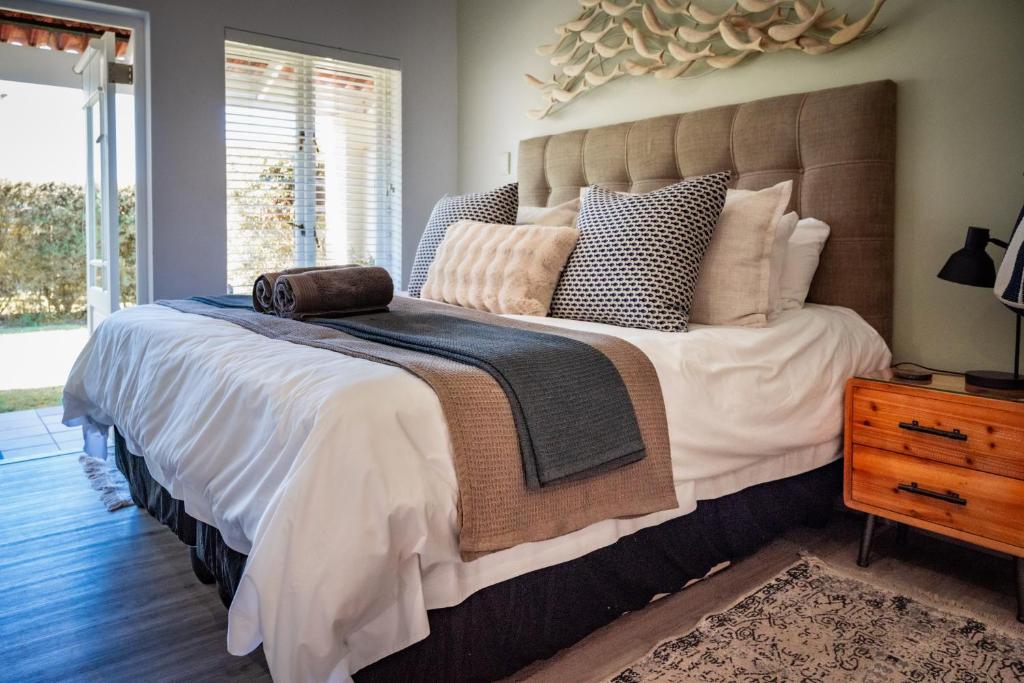 a bedroom with a large bed with a large headboard at The Dunes Haven studio in Keurboomstrand