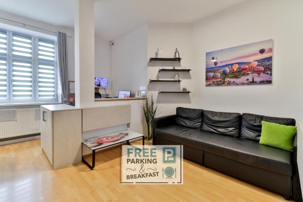 a living room with a black couch and a free parking sign at Hostel u Arény in Ostrava