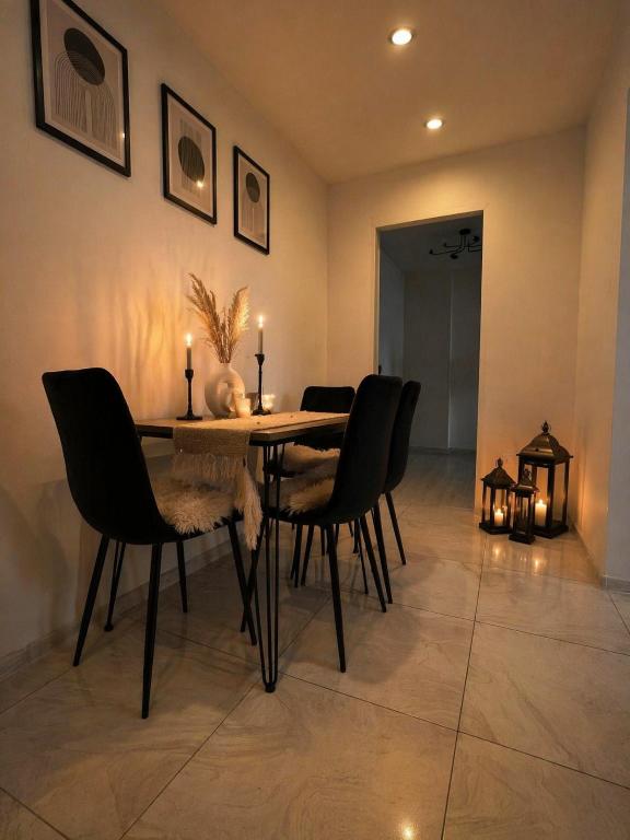 a dining room table with black chairs and candles on it at Apartament w Centrum Prudnika in Prudnik