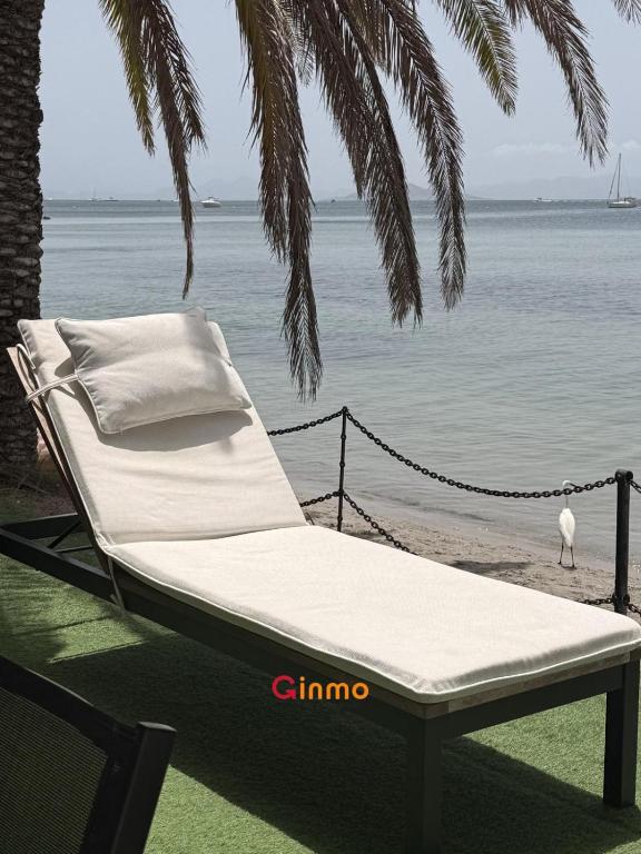 a hammock chair on the beach with a view of the ocean at Chalet en el mar in La Manga del Mar Menor