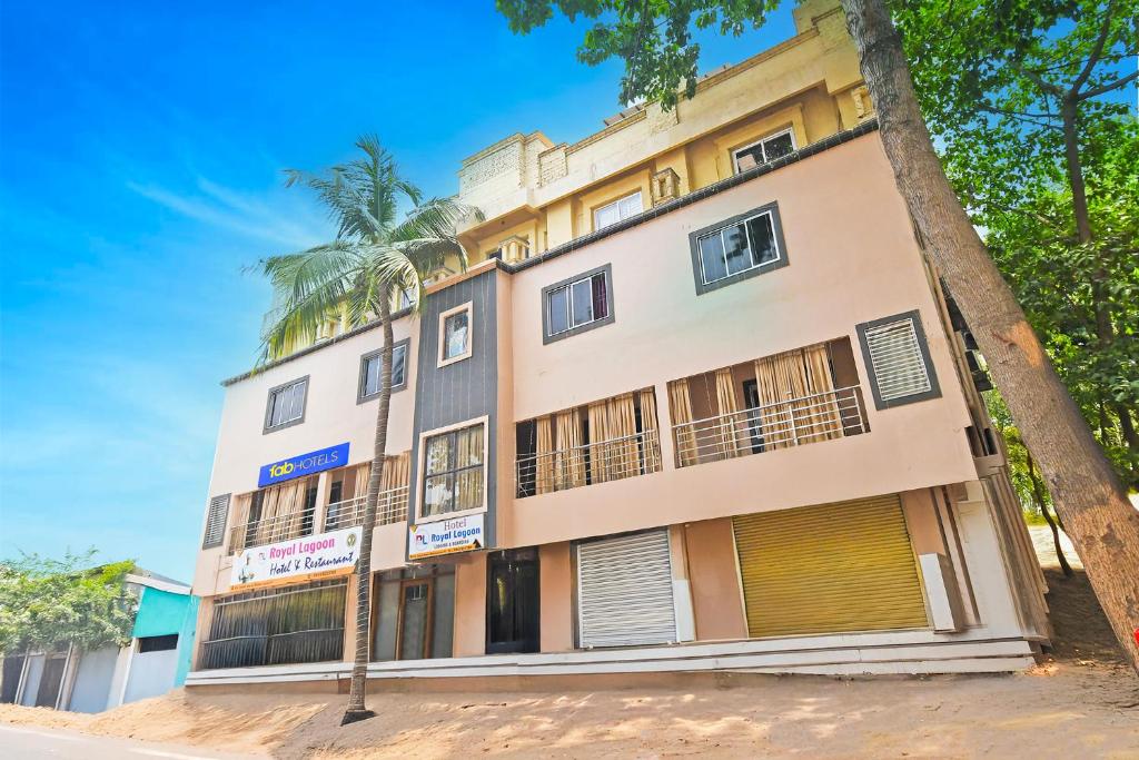 a building with a palm tree in front of it at FabHotel Royal Lagoon in Bhubaneshwar
