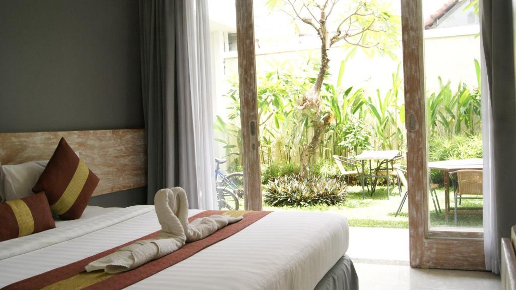 a bedroom with a bed and a sliding glass door at Sugiras Living in Denpasar