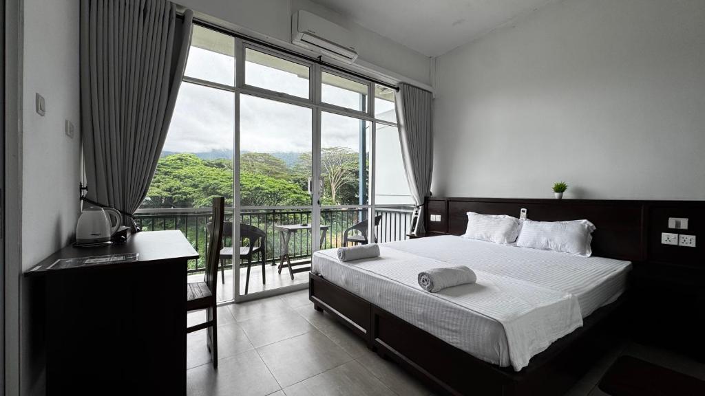 a bedroom with a bed and a large window at Varsity Villa in Kandy