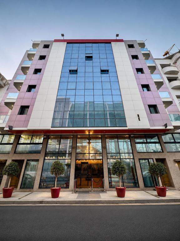a tall building with potted trees in front of it at Majliss Hotel Downtown in Rabat