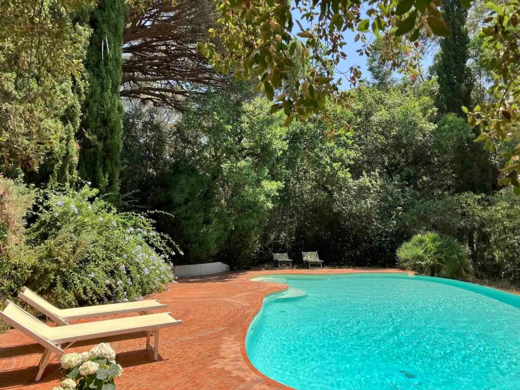 a swimming pool with two chairs and a bench at Roulotte de luxe avec piscine partagée à Ramatuelle in Ramatuelle
