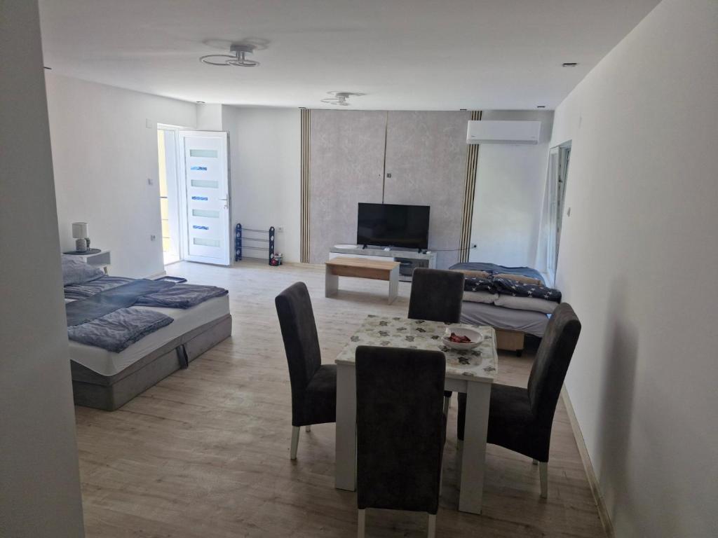 a living room with a dining table and a bedroom at Apartman EC Milica in Stapar