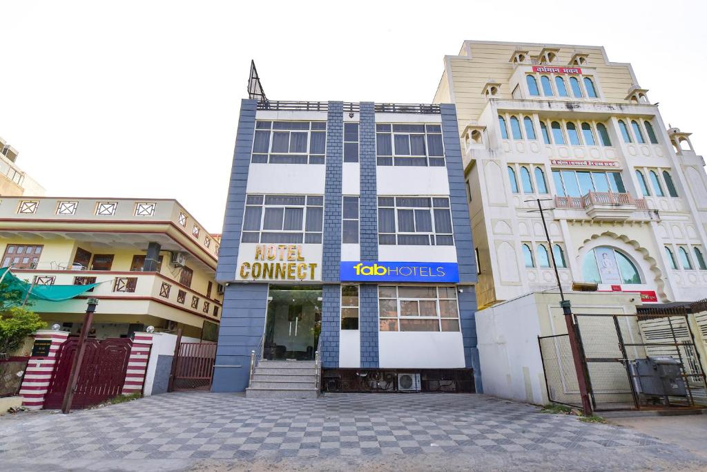 a tall building with a sign on it next to two buildings at FabHotel Connect in Jaipur