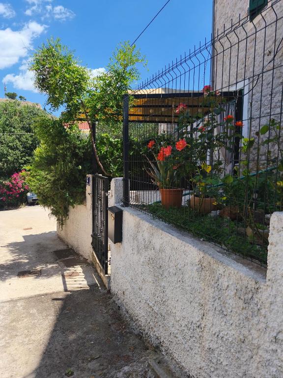 a fence with flowers on the side of a building at Apartman Campo in Šibenik