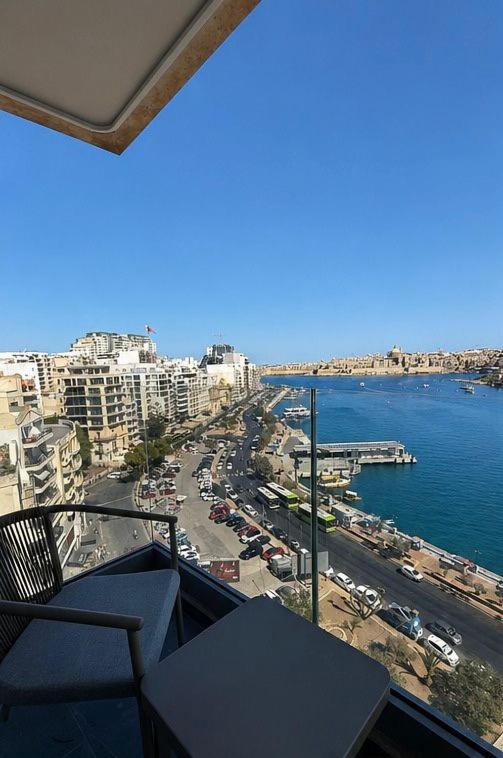 a balcony with a view of a city and the ocean at Sliema Centric Hotel in Sliema
