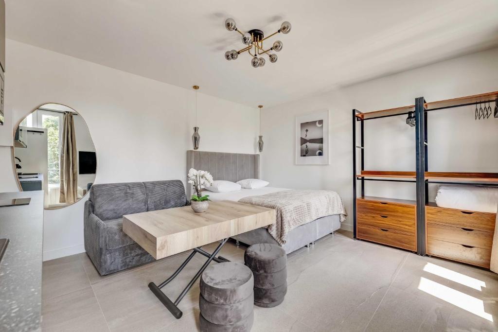 a bedroom with a bed and a table and a chair at Modern Studio 3P - Aubervilliers in Aubervilliers