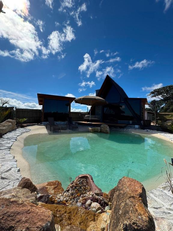 a swimming pool with a house in the background at Chalé lago Azul in Venda Nova do Imigrante