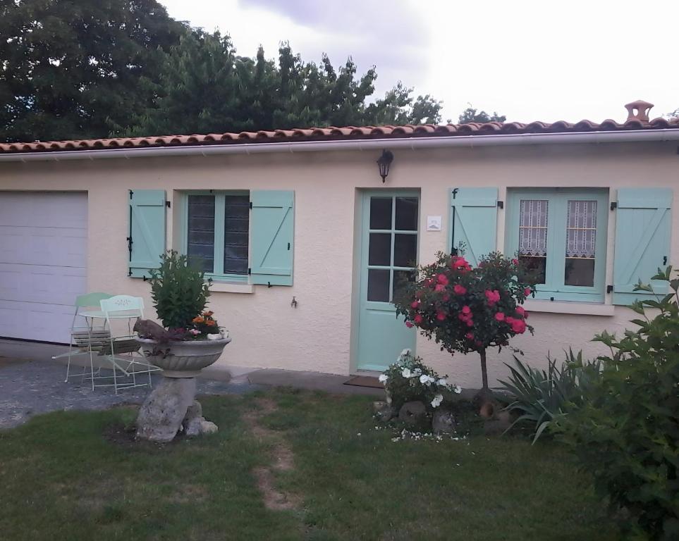 a small white house with blue shuttered windows at Maisonnette à Coulon in Coulon