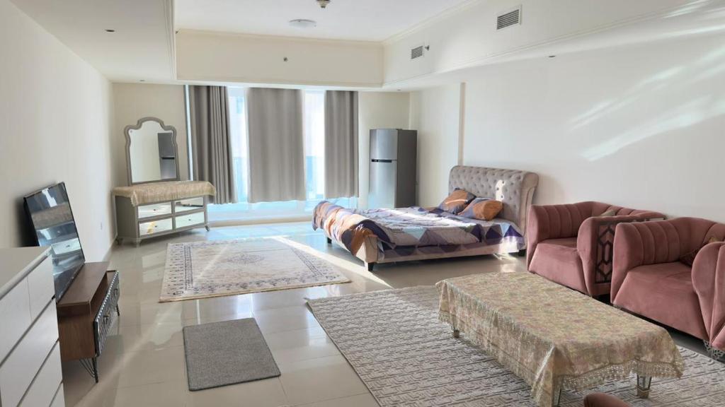 a living room with a couch and a chair and a table at Ajman Beach Apartments in Ajman 