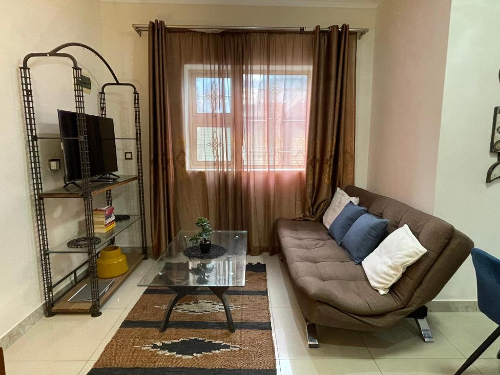 a living room with a couch and a glass table at Nais cottage in Cape Town