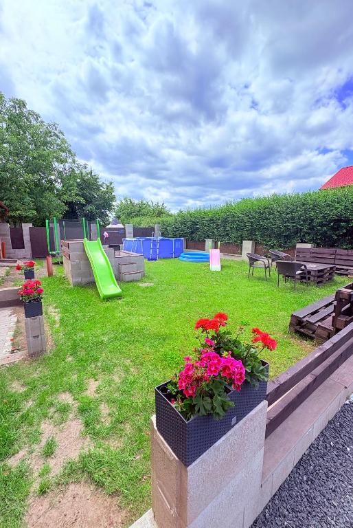 a backyard with a playground with a play area and flowers at Apartmány 68 in Kámen
