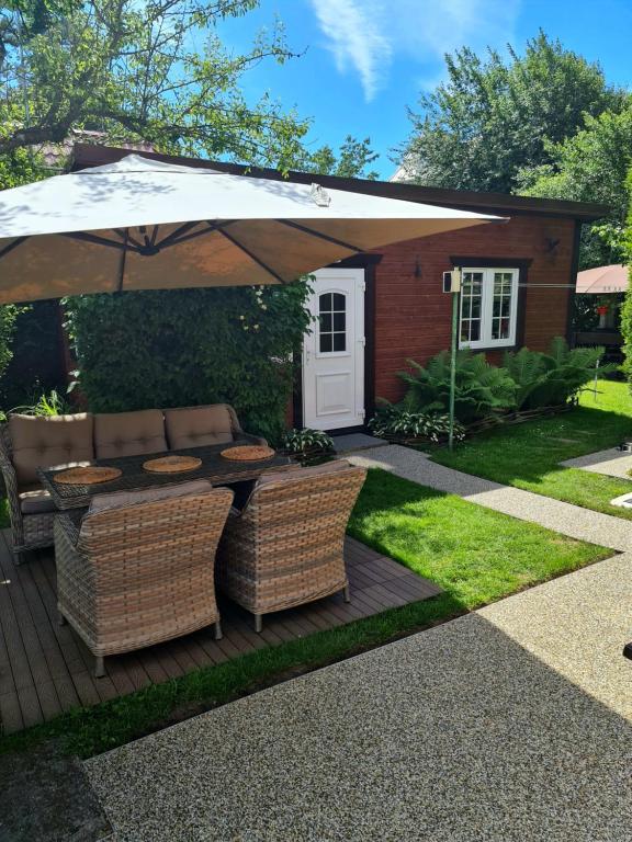 a patio with an umbrella and two chairs and a table at Viešnagė Palangoje pas J&I in Palanga
