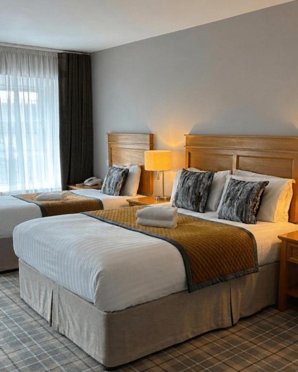 a hotel room with two beds in a room at Fairhill House Hotel in Clonbur