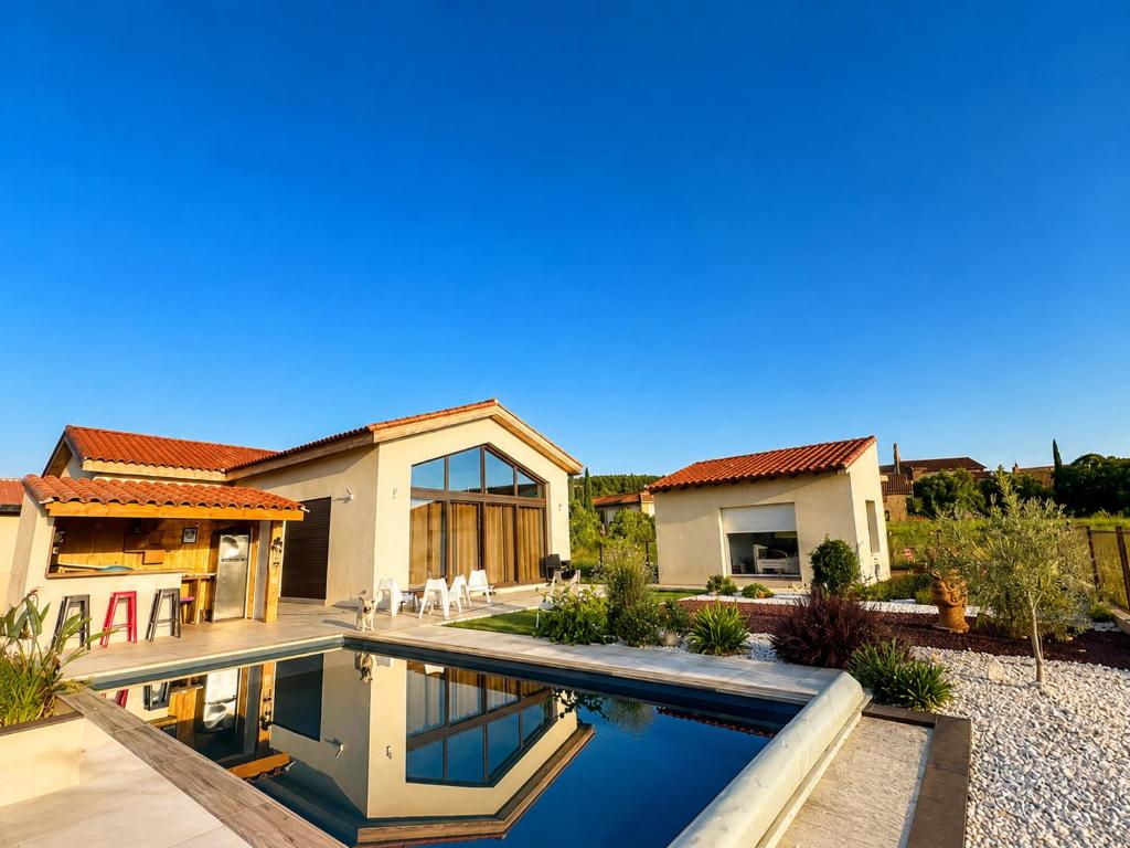a house with a swimming pool in a yard at La Casa del Roc in Sainte-Colombe