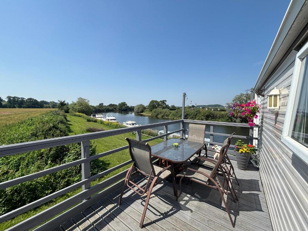 a patio with a table and chairs on a balcony at On the river Severn - Severnside Boat & Caravan Park, Caravan 9 in Tirley