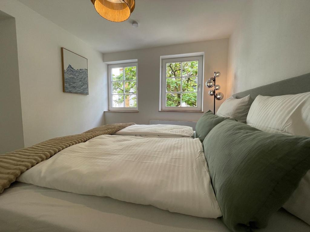 a large bed in a bedroom with two windows at Soul Apartment in Aalen