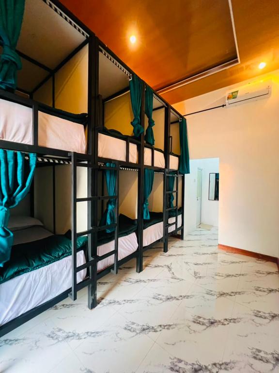 a room with three bunk beds in a room at Snooze hostel lombok in Selong Belanak