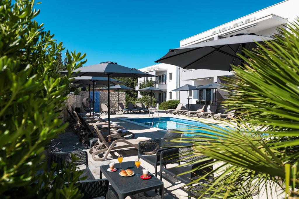 a pool with chairs and umbrellas next to a hotel at 1oak rentals in Vir