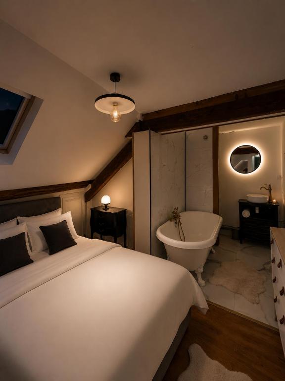 a bedroom with a large bed and a bath tub at le petit château in Chambéry