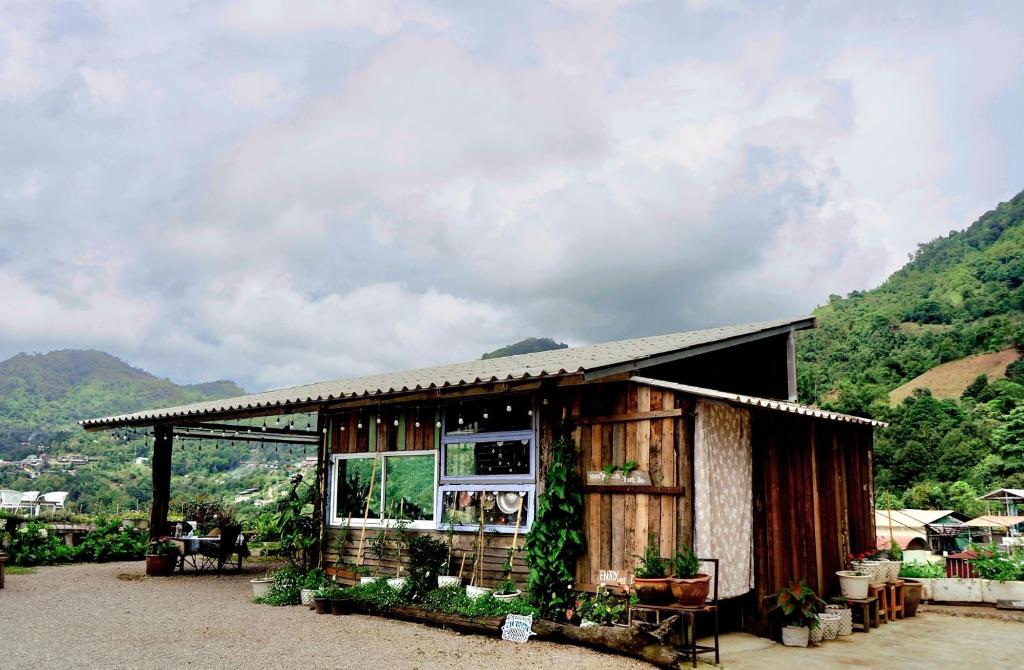 a small wooden building with a table and chairs at พอยื้อใจ doichang in Ban Huai Khai