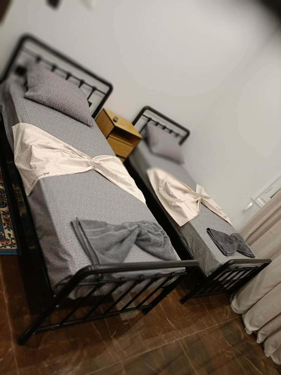 two beds sitting on the floor in a room at Britannia Apartments in Gjirokastër