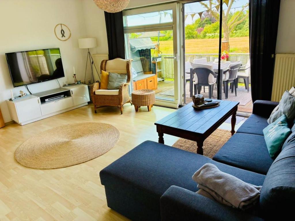 a living room with a blue couch and a table at Ferienwohnung DE VRIESenkoje in Südbrookmerland