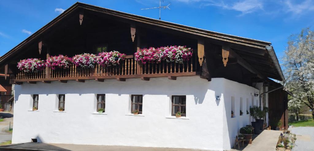 ein weißes Gebäude mit Blumen auf einem Balkon in der Unterkunft Waldglanz Loft in Freyung