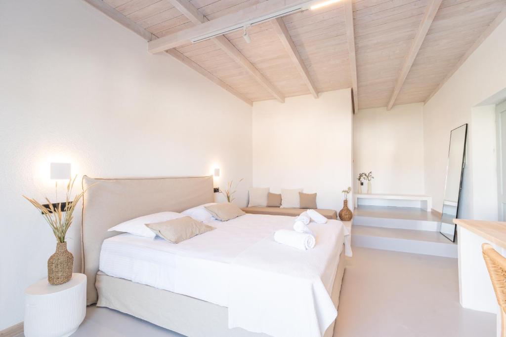 a white bedroom with a white bed in a room at Drio Kythnos Suites in Dhriopís