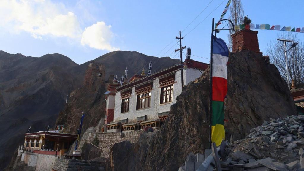a building on the side of a mountain with a flag at Wanla Eco Residence in Tarklak