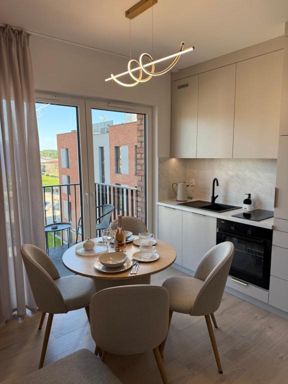 a kitchen and dining room with a table and chairs at Apartament Cysterski Pelplin in Pelplin