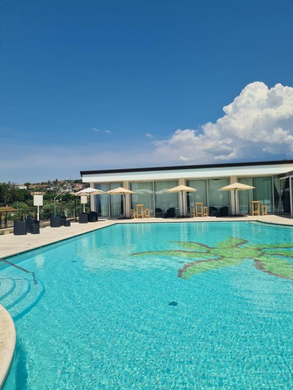 ein großes Schwimmbecken vor einem Gebäude in der Unterkunft 4 SPA Hotel in Catania