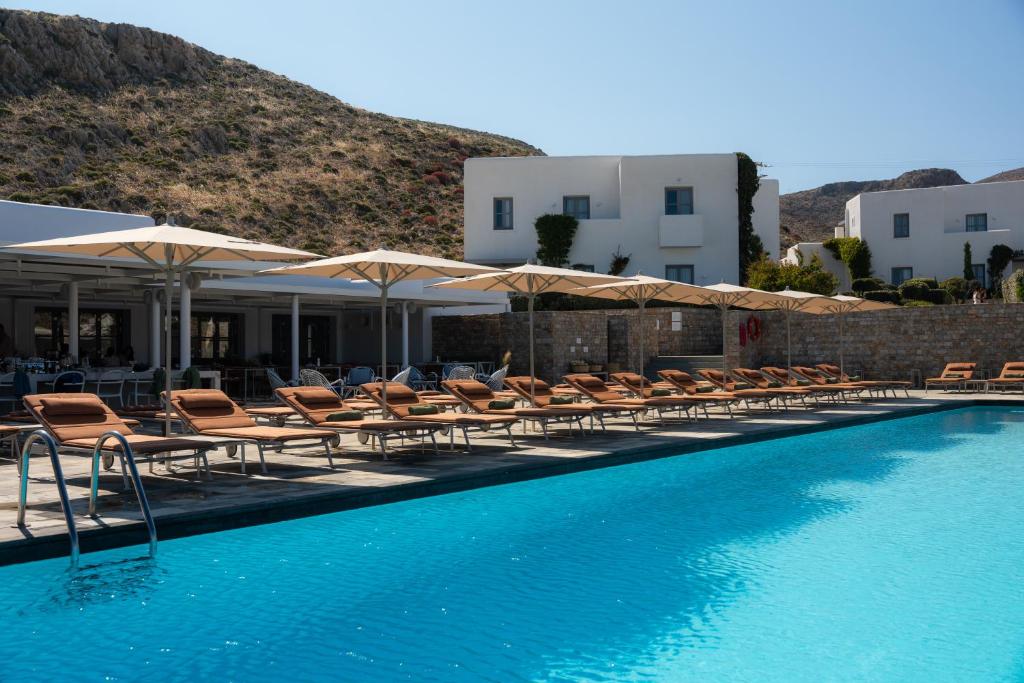 a swimming pool with lounge chairs and umbrellas at ANEMI Folegandros in Karavostasi