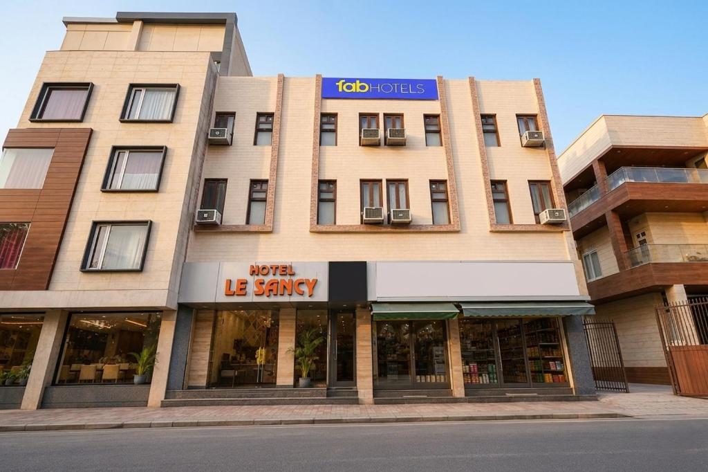 a large building with a sign on top of it at FabHotel Le Sancy in New Delhi