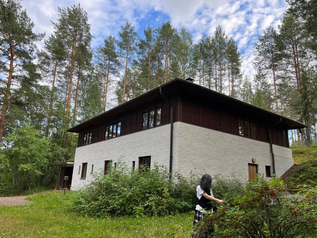 a woman is standing in front of a building at Lakeside house in Sulkava in Sulkava