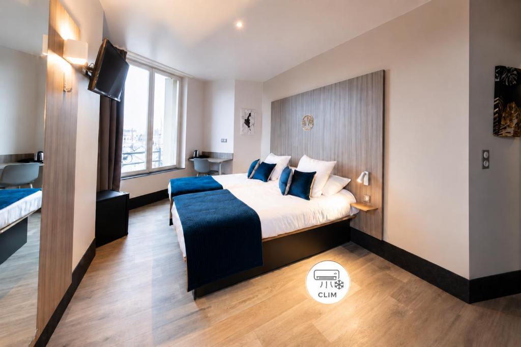 a hotel room with a bed and a large window at Hôtel Nancy Gare-Congrés in Nancy