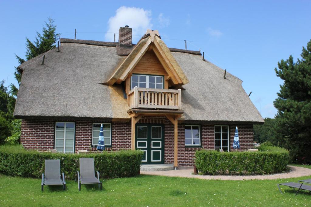 une maison avec un toit en gambrel et deux chaises dans l'établissement Haus Sonnenblume, à Lohme