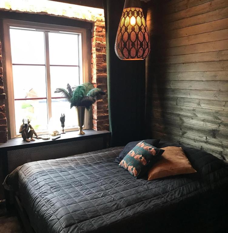 a bedroom with a bed with a window and a lamp at Kronan Bed & Breakfast in Vara