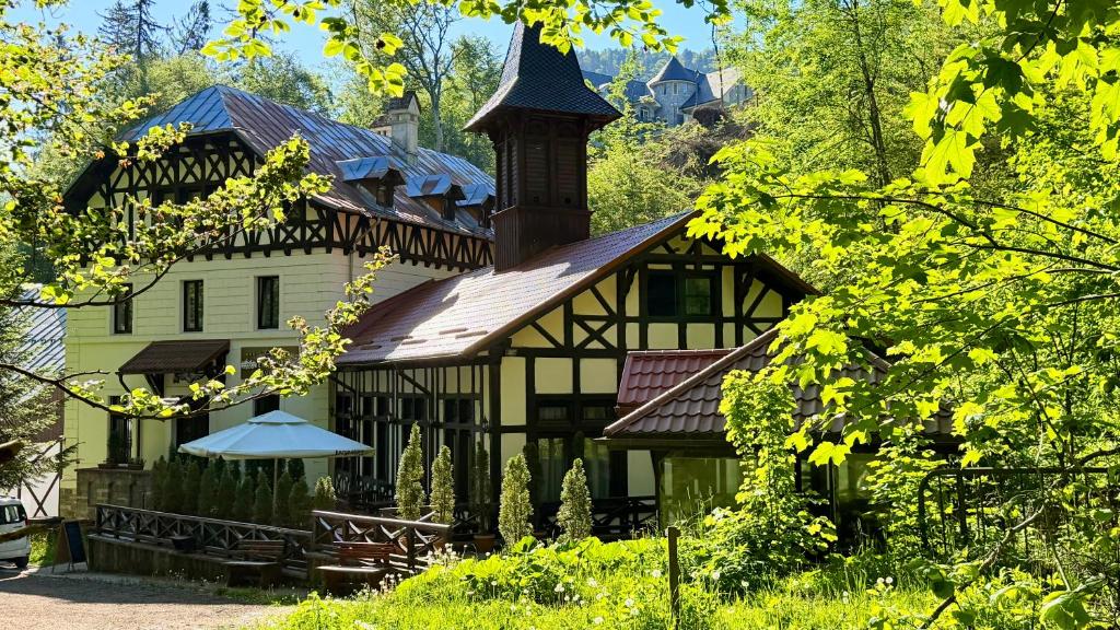 a house with a tower on top of it at Stavilar Hotel - Charming Stay Just Steps Away from Peles Castle in Sinaia in Sinaia