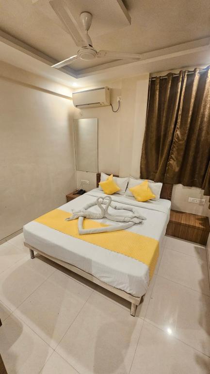 a bedroom with a large bed with a yellow blanket at Hotel Trimurti Executive in Dāpuri
