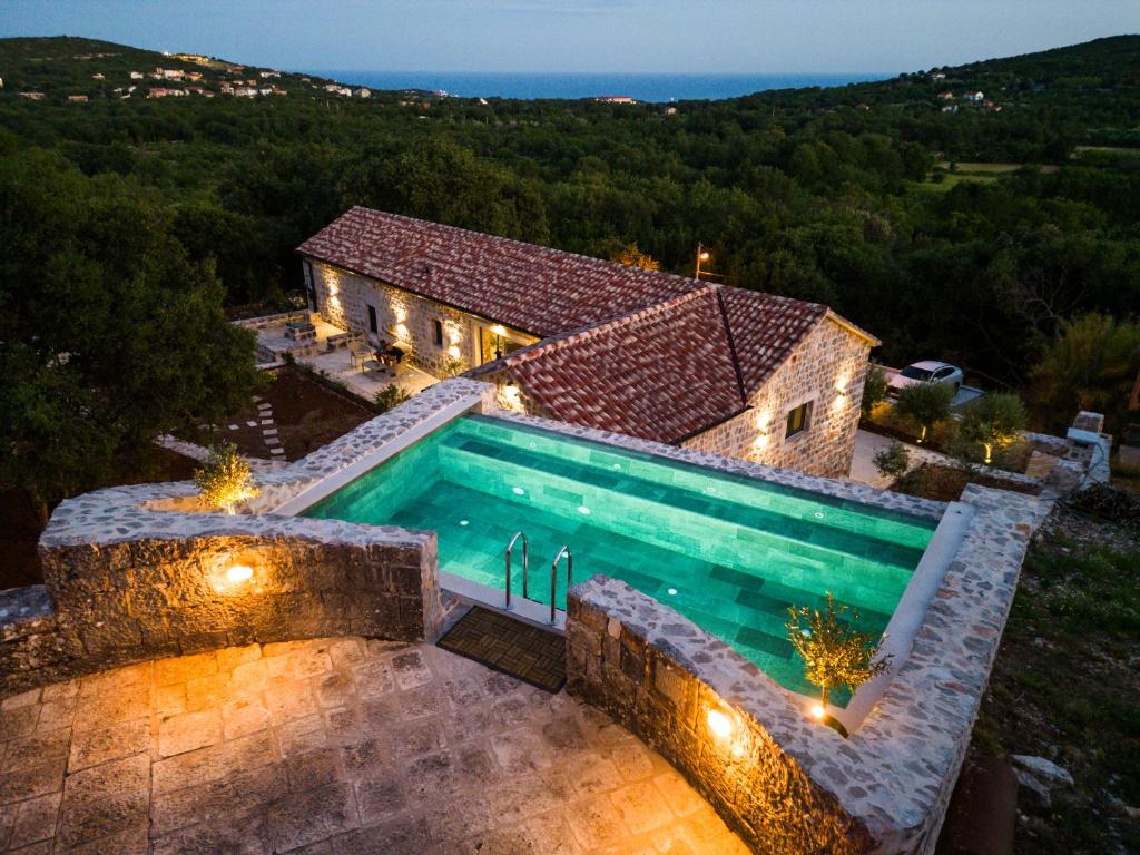 an aerial view of a house with a swimming pool at Heritage House Strahinja Stone Villa with Private Pool in Popovići