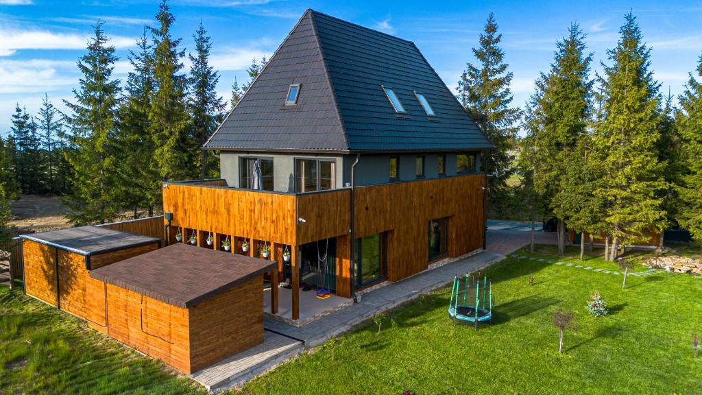 a house with a black roof and a playground at Belis Chalet in Bălceşti