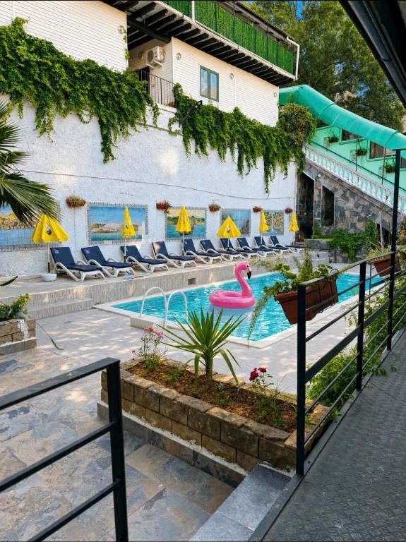 a pool at a hotel with chairs and a pink flamingo at Chalet Duplex N 6 avec piscine in Bouzareah